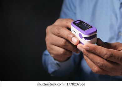 Close Up Of Patient Using Pulse Oximeter Isolated In Black 