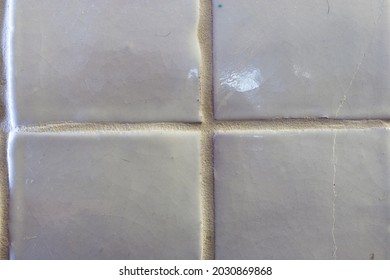 Close Up Of A Pearl White Tile. The Background Texture Features Course Grout Lines And Smooth And Weathered Ceramic Tile.