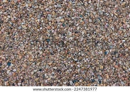 Close up pebble beach background. Conceptual earthy tones wallpaper with lava stones and beautiful  pebbles. 