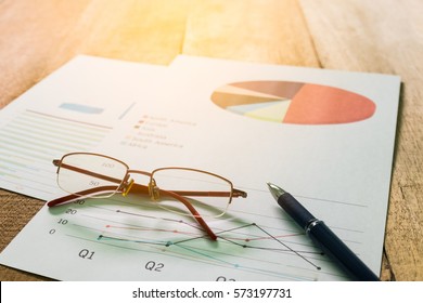 Close up pen with summary report and eyeglasses on table office. Concept of Data Analysis, Investment Planning, Business Analytics.