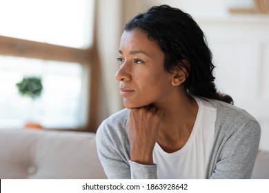 Close up of pensive dreamy young African American woman look in distance thinking or planning. Thoughtful millennial biracial female dreamer imagine or visualize, lost in thoughts. Vision concept. - Shutterstock ID 1863928642