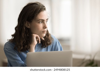 Close up pensive freelance woman working on laptop, thinking over ideas for project, staring away, feels puzzled. Serious student ponder on essay insights, search problem solution, analyze information - Powered by Shutterstock