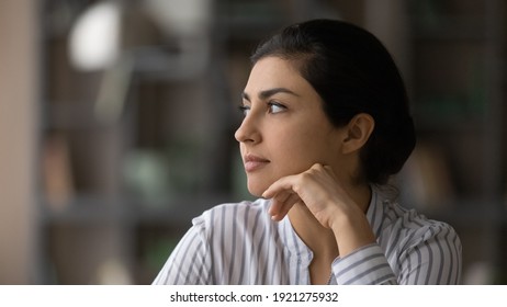 Close Up Of Pensive Indian Woman Look In Distance Thinking Pondering Or Life Choices Make Solution. Thoughtful Millennial Mixed Race Ethnicity Female Decide Or Plan. Visualization Concept.