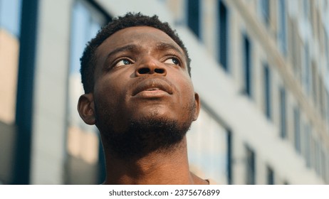 Close up pensive thinking ethnic man looking around outdoor business student guy look up on urban building think thoughtful African American male tourist contemplate outdoors outside lost in city - Powered by Shutterstock