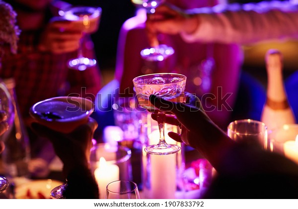Close up\
of people drinking cocktails in restaurant. People having good\
time, cheering and drinking cold cocktails, enjoying friendship\
together in restaurant, close up view on\
hands.