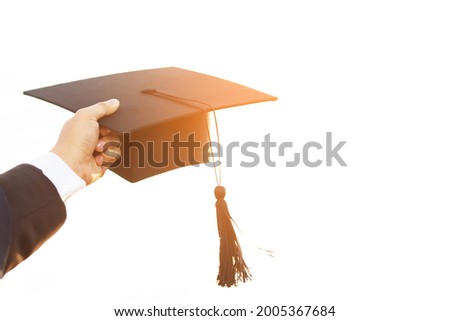 close up people show hand hold show hat in background School building. Shot of graduation cap during Commencement University Degree Concept , Celebration Education Student Success Learning Concept.