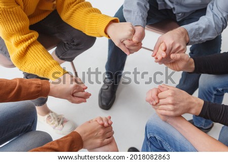 Close up people sit in circle holding hands participating at group therapy session. Receiving sharing psychological support, go through addiction together, help each other overcome dependence concept