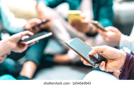 Close up of people using mobile smart phones - Detail of friends sharing photos on social media network with smartphone - Technology concept and cellphone culture with selective focus on right hand - Shutterstock ID 1654563043