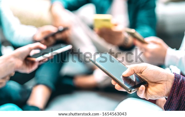 Close up of people using mobile smart phones -\
Detail of friends sharing photos on social media network with\
smartphone - Technology concept and cellphone culture with\
selective focus on right\
hand