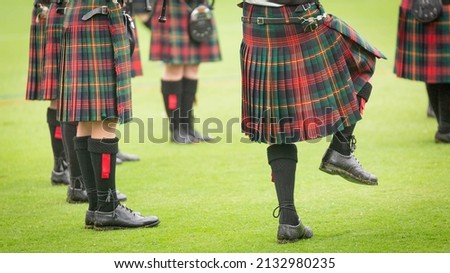 Close up of people wearing kilts doing a jig with feet. 