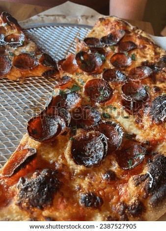 Close up of pepperoni pizza with cup and char pepperoni 