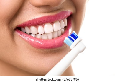 Close up of perfect and healthy teeth with electric toothbrush 