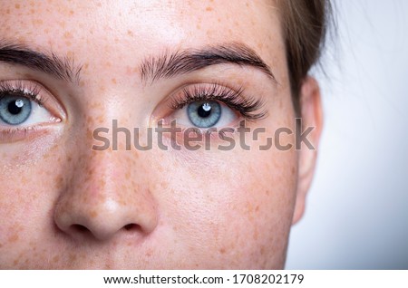 A close up of a person with blue eyes looking at the camera