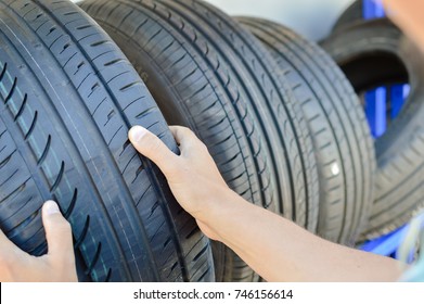 Close up of person checking examining car tyre on the shelf abstract transportation background. Automobile warehouse business, factory production. Protector surface texture - Powered by Shutterstock