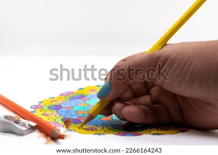 Close up of a person coloring a mandala seen from the front selective focus