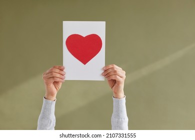 Close Up Of Person Hold Paper Sheet With Red Heart Painted Show Love And Care. Woman Demonstrate Heart Sign On Paperwork Support Those In Need. Volunteer And Charity Concept. Gratitude.