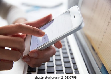 Close Up Of Person At Laptop Using Mobile Phone