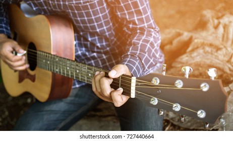 close up person man's hands playing acoustic guitar / Artist / musician