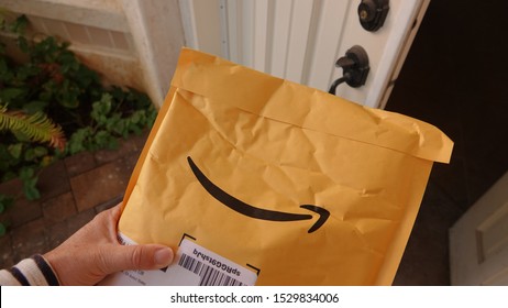 Close Up Of A Person Picking Up An Amazon Prime Delivery Package And Taking It Inside. Illustrative Editorial Taken On October 13, 2019 In Vista, CA / USA.