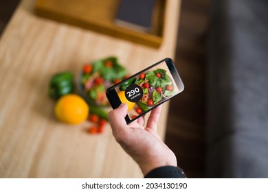 Close Up Of A Person Taking A Picture With A Smartphone Of His Green And Vegetables To Use A Calorie Counting App 