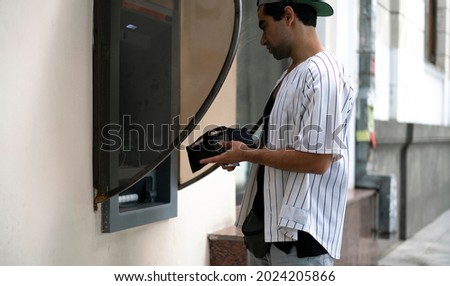 close up person using ATM to take some cash money from bank card 