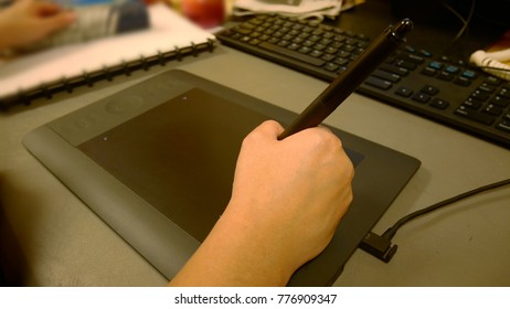 A close up of a person using a drawing tablet