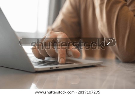 Close up of person using laptop with virtual search bar interface at modern workspace. Online search, web browsing, SEO marketing and digital information technology concept for business communication.
