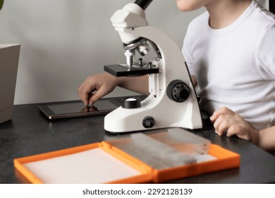 close up of a person using a microscope, science lab school kids concept