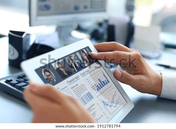 Close up of person video conferencing with\
colleagues on digital tablet, analyzing financial statistics\
displayed on the digital tablet\
screen.