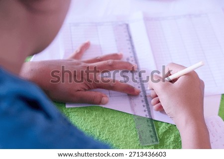 Close Up Person Writing Study Notes wile using ruler and pen