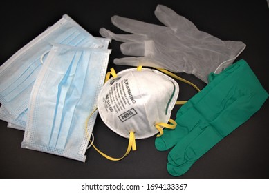 Close Up Of Personal Protective Equipment On Black Background. N95 Respirator,surgical Masks And Gloves,examination Glove.Abstract Photo Of PPE.Worn To Avoid Cross Contamination.Top View,April 02,2020