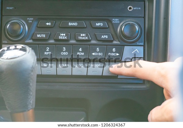 close up person\'s hand push the car radio stereo\
system, searching for\
song