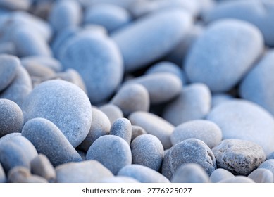 Close perspective capturing the absolute purity and unblemished surfaces of countless pale stones resting on a quiet beach.