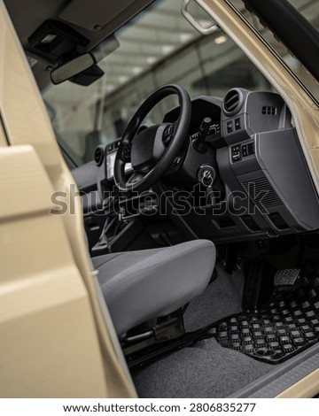 Close up perspective of a driving simulator cockpit showing steering wheel pedals and control panel for racing practice and training