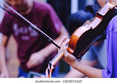 Close up pf teen high school students studying and playing violin at outdoor. Youth art, music club lifestyle and learning background.