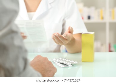 Close Up Of A Pharmacist Reading Leaflet Of A Medicine To A Patient In A Pharmacy Indoor