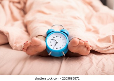 Close up photo of alarm clock and woman trying to wake up - Shutterstock ID 2205895871