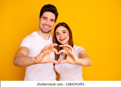 Close up photo amazing beautiful she her he him his guy lady hands arms fingers make heart figure form romance mood hugging sincere wear casual white t-shirts outfit isolated yellow background