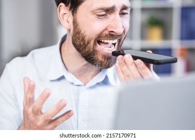 Close Up Photo. Angry And Annoyed Office Worker. He Talks On His Mobile Phone, Shouts. Sitting At A Computer Desk.