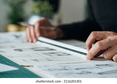 Close Up Photo of Architect Hands Drawing Blueprint Design. 
				Unrecognizable furniture designer sketching drawing design of plant stand using a paper, pen and ruler while sitting at his desk.