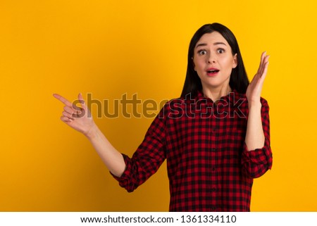 Close up photo of attractive pretty beautiful she her lady finger up to empty space wondered if to buy buyer shirt ask advise wearing shirt isolated on yellow vivid background