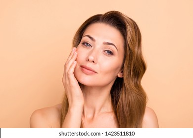 Close up photo beautiful amazing mature she her lady overjoyed after salon spa procedures aesthetic pretty ideal appearance nude arm hand palm touch cheek perfection isolated pastel beige background