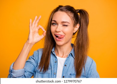 Close Up Photo Of Beautiful Brunette She Her Lady Pretty Hairdo Okey Gesturing Eye Blinking Silly Tongue Out Of Mouth On Upper Lip Wearing Casual Jeans Denim Shirt Outfit Isolated On Yellow Background