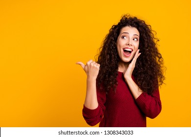 Close up photo beautiful cheerful amazing her she lady showing way one arm thumb other cheek wondered look empty space wearing red knitted sweater pullover clothes outfit isolated yellow background