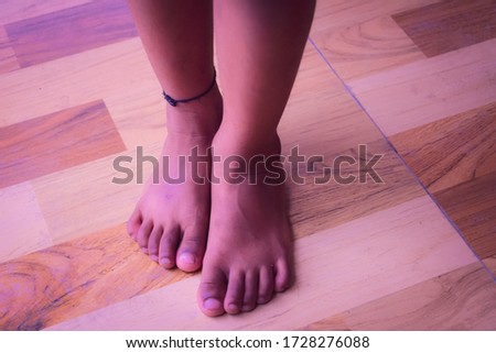 A close up photo beautiful dusk brown skin tone barefoot picture of a boy child.