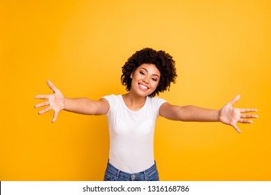 Close up photo cheerful beautiful amazing she her dark skin lady spread hands arms come here to us calling in hugs sweetheart wear casual white t-shirt isolated yellow bright vibrant background