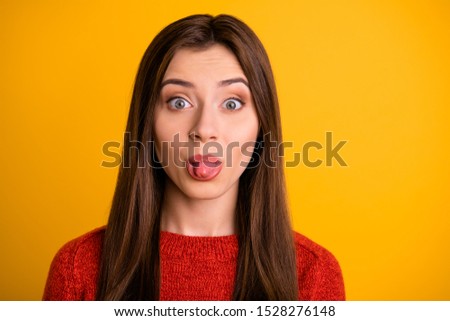 Close up photo of cheerful cute charming gorgeous sweet pretty girl sticking her tongue out to tease you isolated over yellow vivid color background