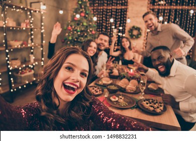 Close up photo of cheerful fellows in formal wear sit around  table enjoy christmas party x-mas holidays making selfie in house full of noel decoration