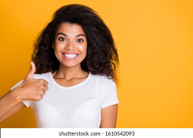 Close up photo of cheerful positive nice cute girlfriend showing you thumb up to demonstrate perfect work of her dentist in white t-shirt curly wavy brown haired isolated vivid color background