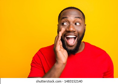 Close up photo of cheerful positive playful man telling someone secrets of him announcing important information while isolated with yellow background